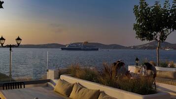 A waterfront seating area with a view of a cruise ship named Blue Star Ferries.
