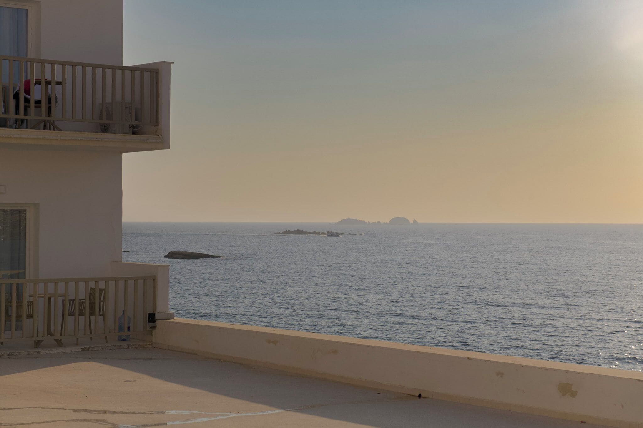Uma varanda com vista para o mar e ilhas ao longe.
