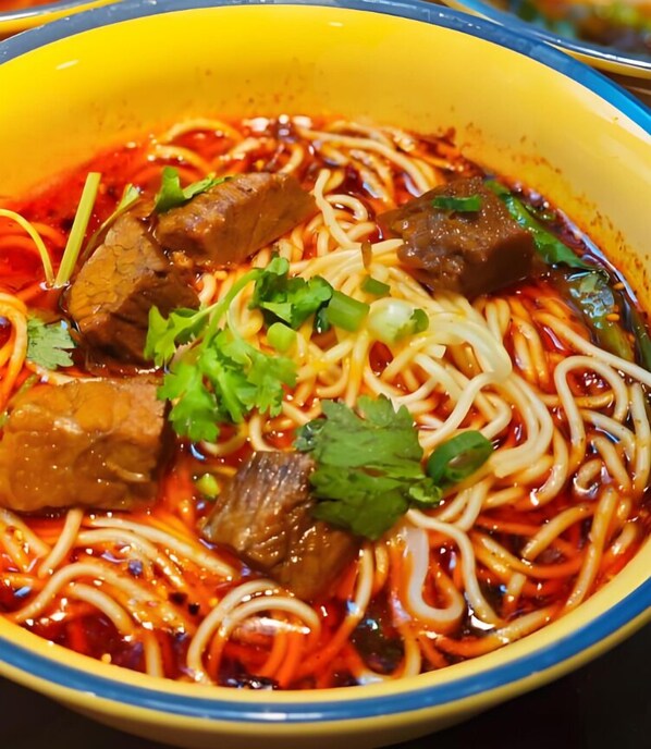 A bowl of noodle soup with beef and cilantro. - Mango restaurant and apartment hotel (Zanzibar Town)