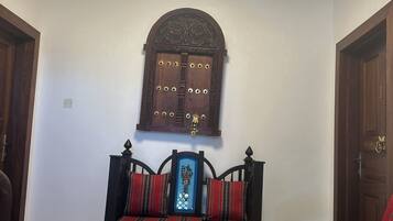 A room with a wooden bench, a wall-mounted decorative panel, and a door.