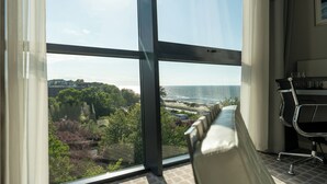 A modern office space with a large window overlooking a beach and cityscape. - Apartamenty Sun & Snow Marine (Kolobrzeg)