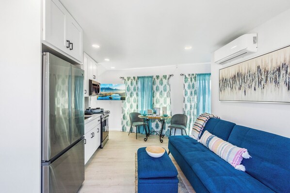 A compact living space with a kitchenette, a dining area, and a sofa.