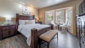 A bedroom with a large bed, bedside tables, a bench, a chair, and a TV. - Lake Haven- Spacious 5-bedroom, Kings Beach, 12 guests- pet friendly (Kings Beach)
