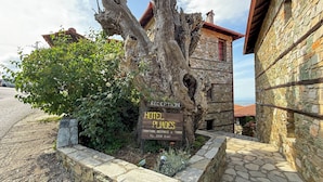 Une maison d’hôtes traditionnelle, avec une façade en pierre et une enseigne indiquant qu’il s’agit d’un hôtel.