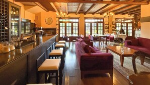 Un restaurant chaleureux avec des poutres en bois, un bar et des sièges confortables.