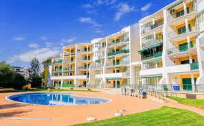 A multi-story hotel with balconies, a swimming pool, and a well-maintained lawn. - Apartament Spring  w/ pool (Portimão)