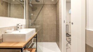 A modern bathroom with a glass-enclosed shower, a wooden vanity, and a large mirror. - Ai Vicoli Ciambra's Alley - Suite Guglielmo by Wonderful Italy (Monreale)