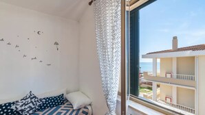 A balcony with a view of a building and the sea.
