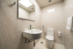 A modern bathroom with a white sink, mirror, and toilet. - Zapbed House-ONT 405 (Dubai)