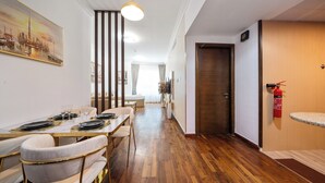 A dining area with a long table, chairs, and a hanging light fixture.