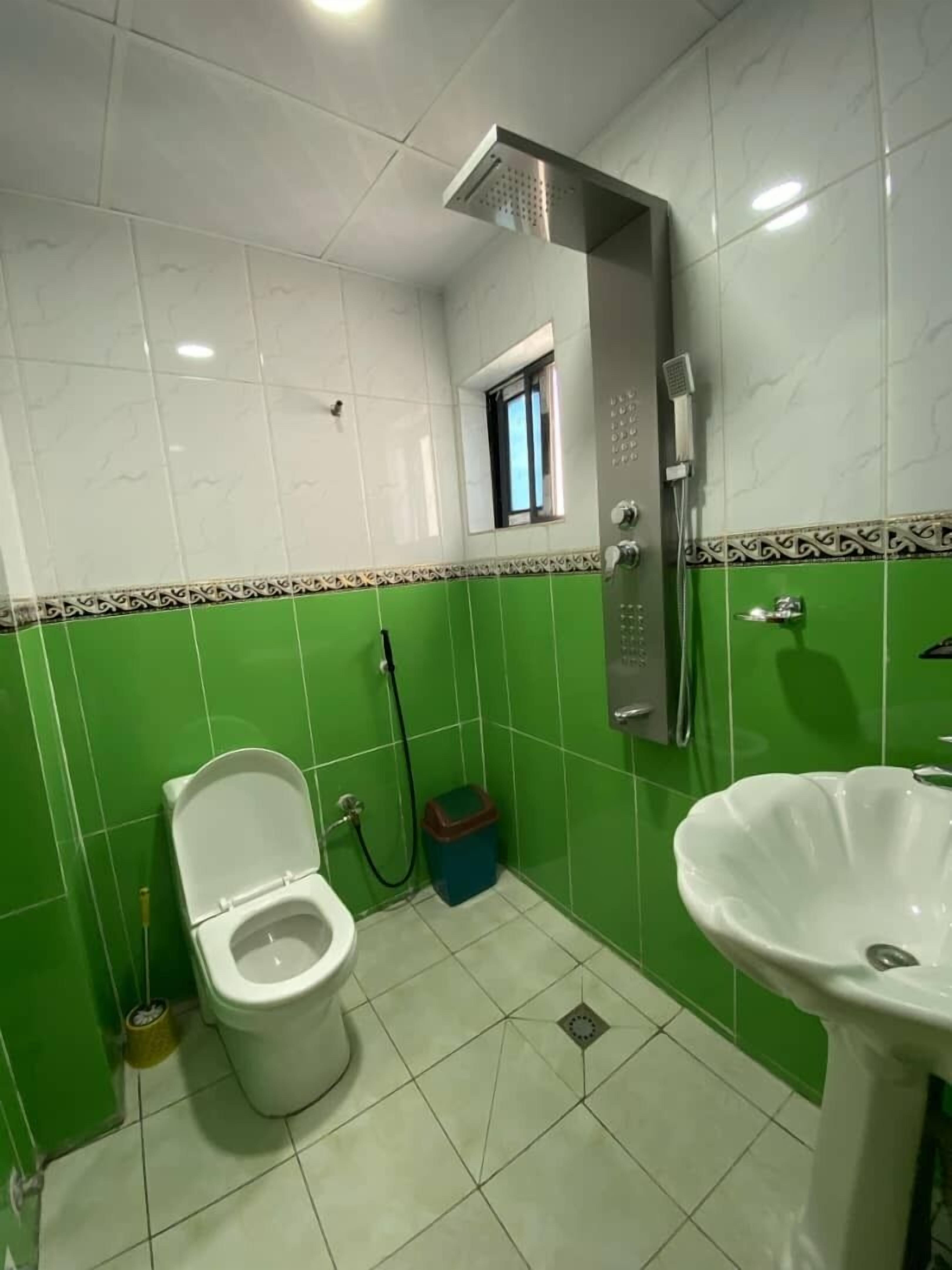 Un baño con inodoro, lavamanos y ducha.