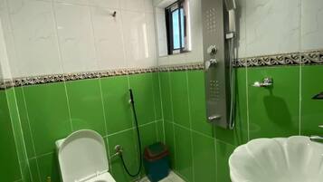 Un baño con inodoro, lavamanos y ducha.
