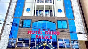 A multi-story building with a prominent sign reading "HOTEL GUIKO PALACE". - Guiko Palace Hotel  (Douala)
