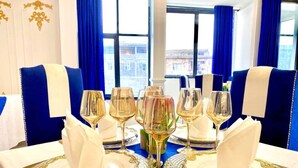 A table set with gold and white dinnerware, glasses, and a centerpiece. - Guiko Palace Hotel  (Douala)