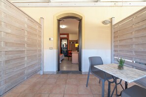 A narrow corridor with a tiled floor leading to a room with a bed, a sink, and a chair. - Hotel Al Ritrovo (Castelluzzo)
