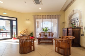 A dining area with a table and chairs, a potted plant, and a cabinet with decorative items. - Hotel Al Ritrovo (Castelluzzo)