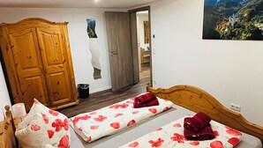 Una camera da letto con due letti, un armadio in legno e un quadro appeso al muro.