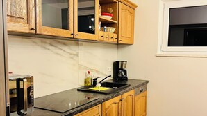 Una cucina con mobili in legno, un piano di lavoro nero e una finestra.