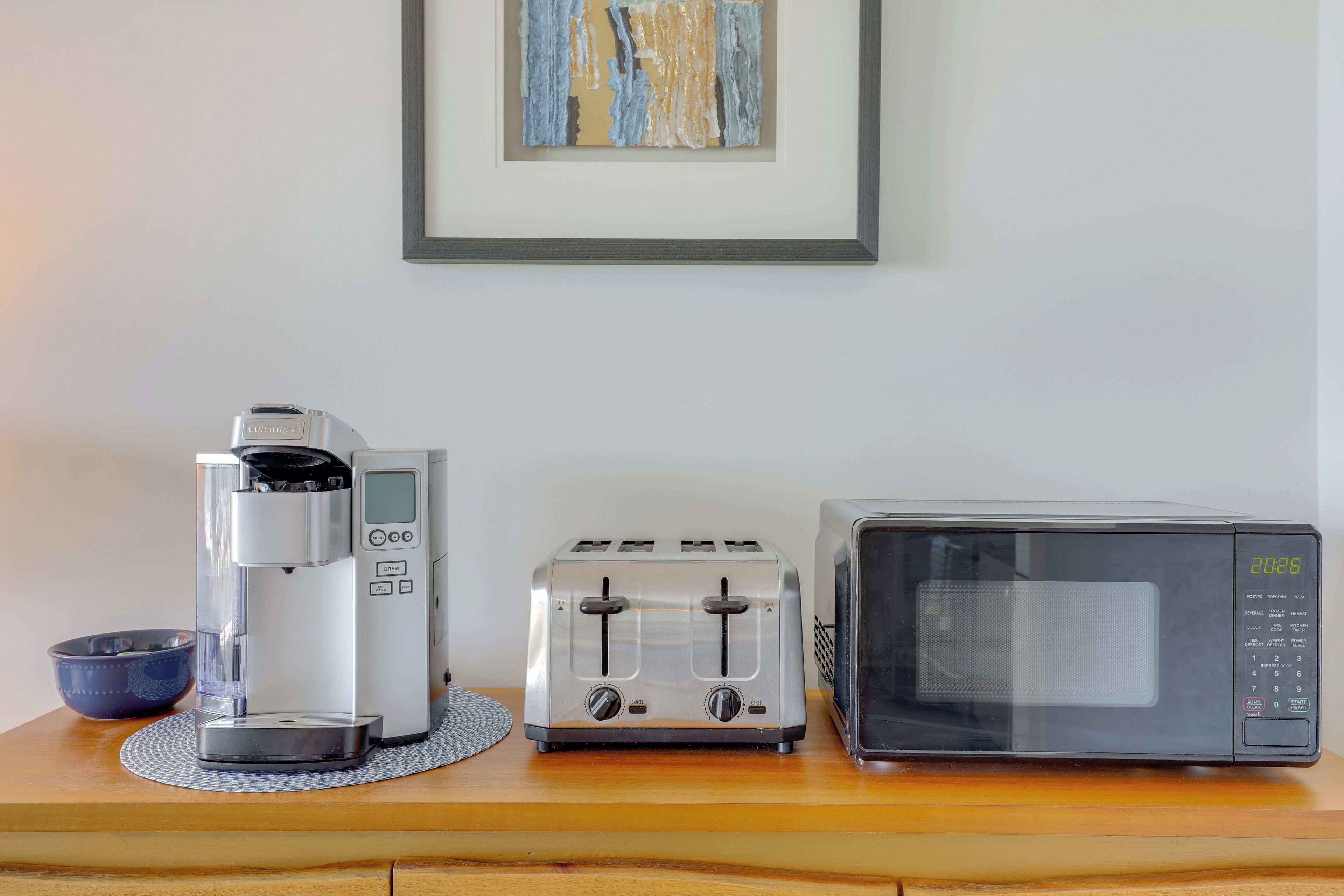 A kitchen counter with a coffee maker, toaster, and microwave.