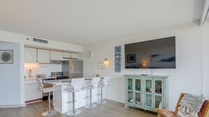 Eine moderne Küche mit weißen Schränken und einem Essbereich mit Barhocker.