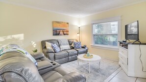 A living room with a sofa, a coffee table, a lamp, and a TV.