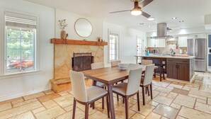 A spacious kitchen with a central island, a dining area with a wooden table and chairs, and a fireplace. - 3 Mi to Dtwn Shops & Eats: Mesa Home w/ Pool! (Mesa)