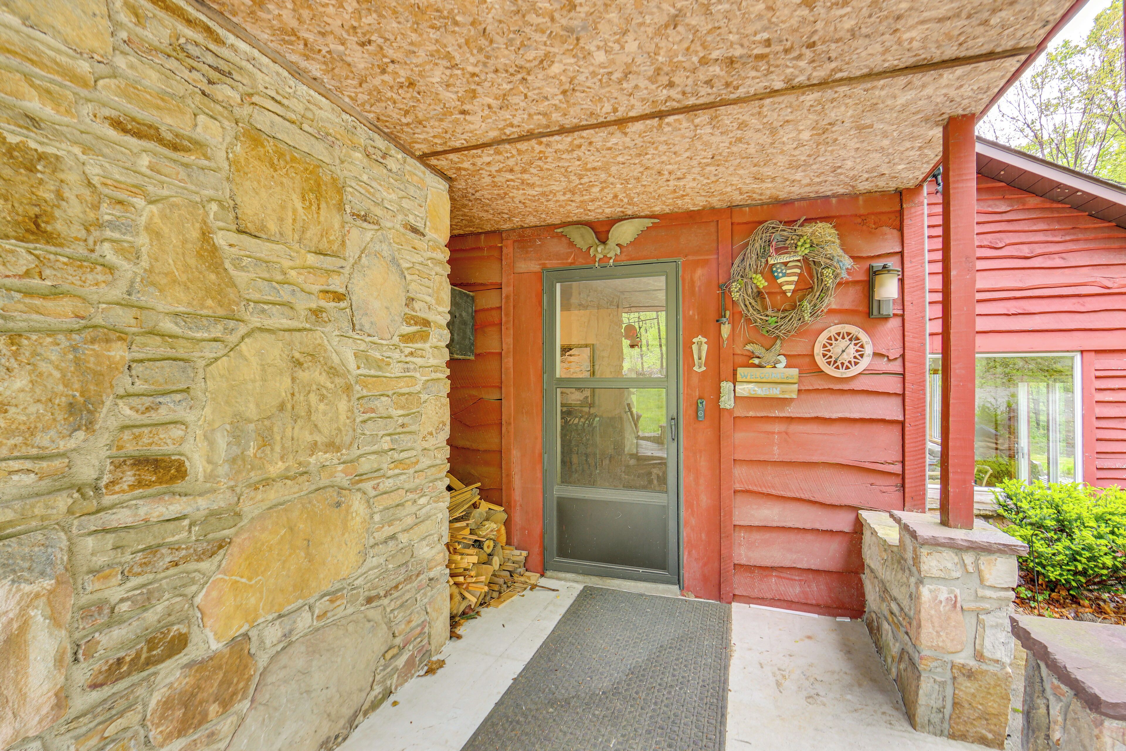 A stone exterior wall, a wooden door with a glass panel, a wreath, and a small step leading to a porch.