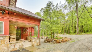 A red building with a stone foundation and a covered porch.