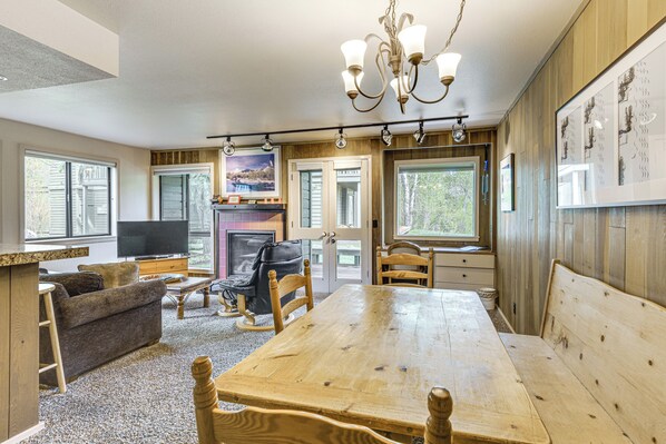 Cozy living area with a dining table, comfortable sofa, and fireplace.