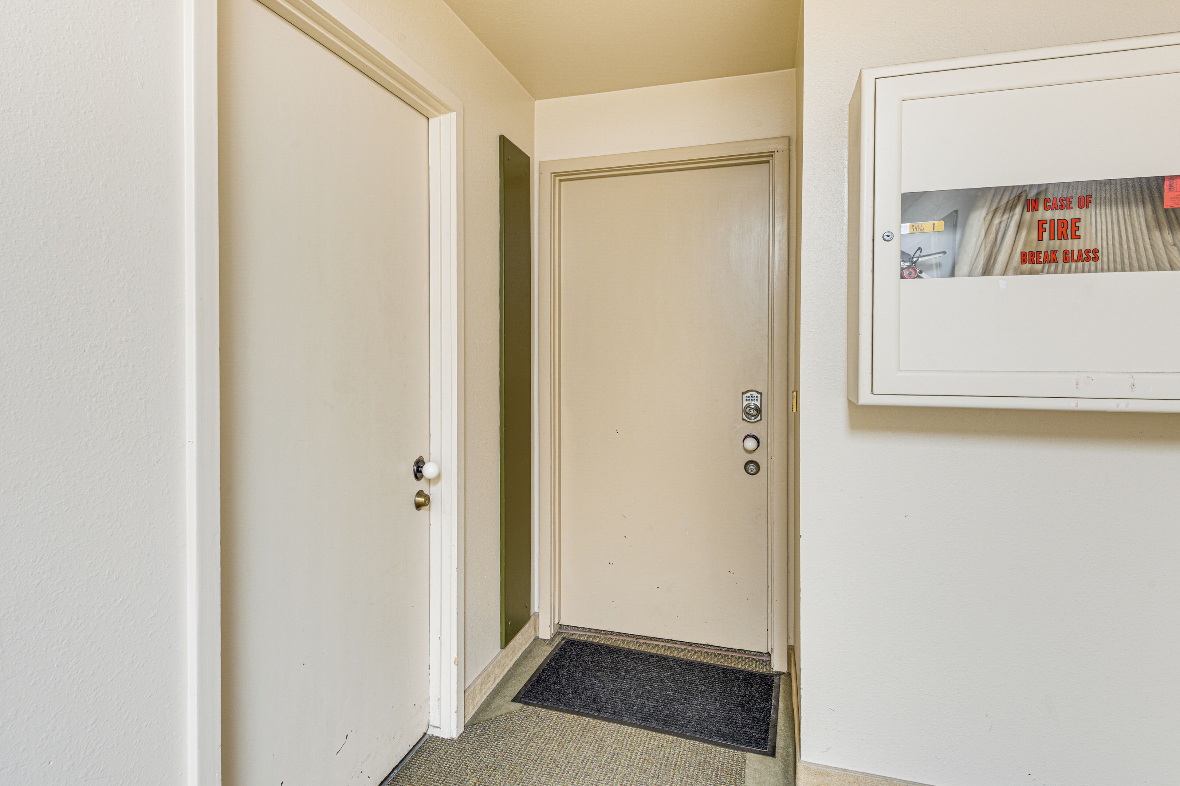 A closed door with a doorknob and a small mat at the entrance.
