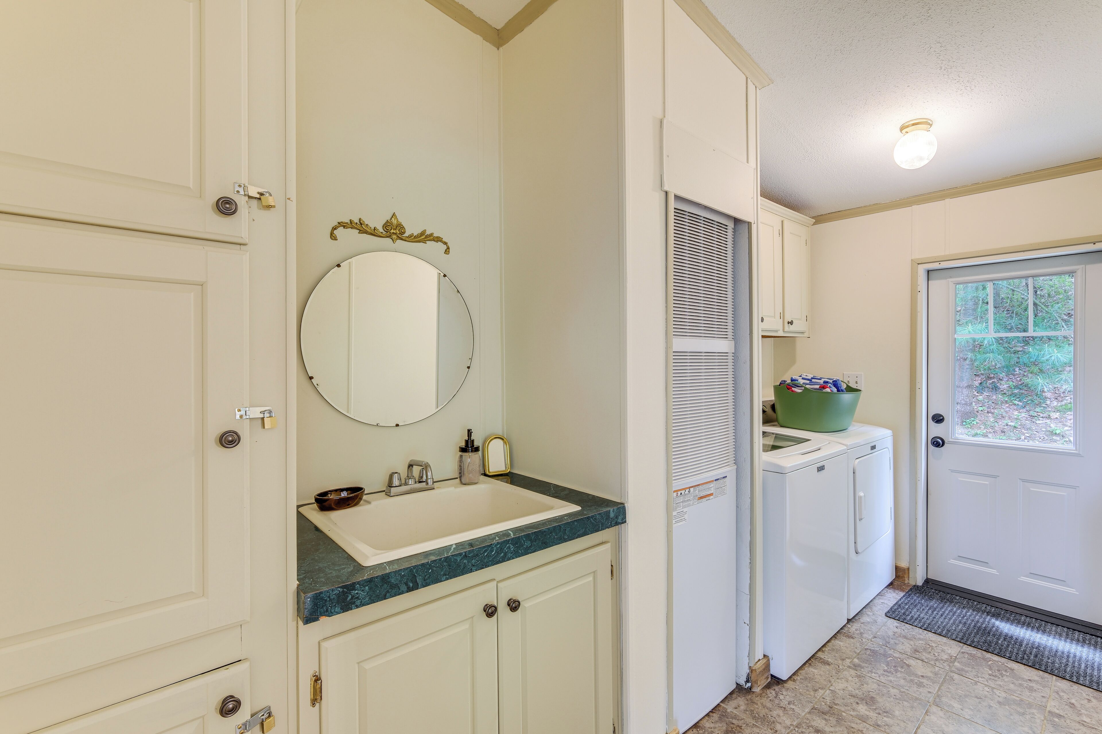 A bathroom with a sink, mirror, and cabinets.