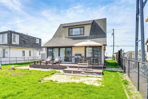A residential property with a patio area, outdoor seating, and a barbecue grill.