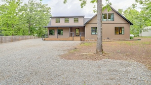 Un bâtiment à deux étages avec une allée en gravier et une terrasse en bois.
