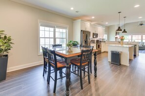 Una cocina amplia con una isla grande, sillas de madera y una mesa de comedor.
