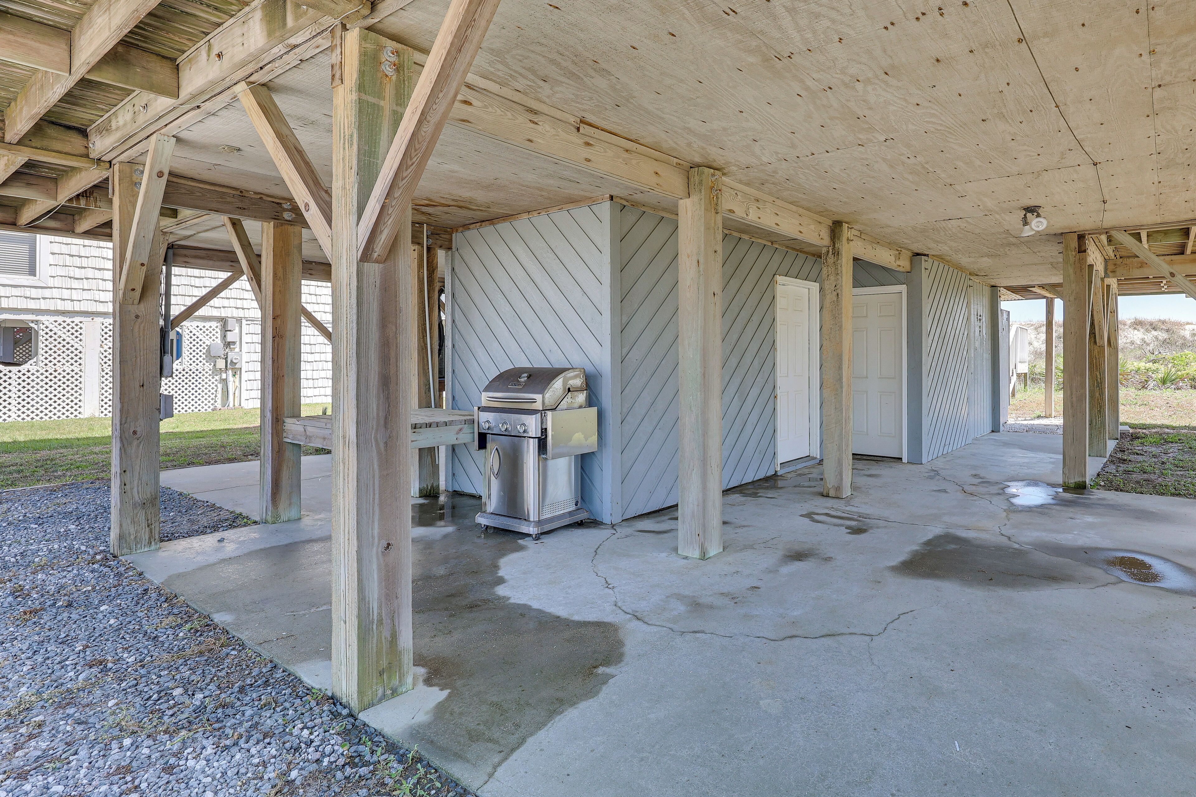 A covered outdoor area with a grill and a water heater.