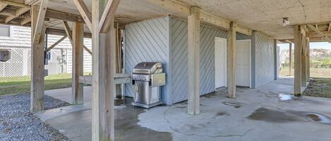 A covered outdoor area with a grill and a water heater.