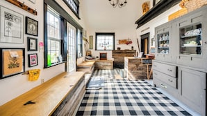 A kitchen with a checkered floor, wooden cabinets, and a bench. - True North Farm House - Historic Family Home (Irasburg)