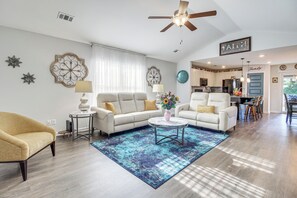 A spacious living room with a ceiling fan, a sofa, a coffee table, and a rug. - 1 Mi to Shopping District: Chic Springfield Home (Springfield)