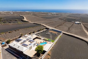 Una propiedad costera con piscina, paneles solares y campos en terrazas.