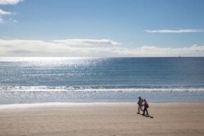 Una playa con cielo despejado y mar tranquilo.
