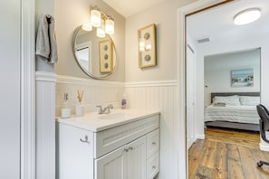 A bathroom with a white vanity, a large mirror, and a framed picture on the wall. - 3 Mi to Mashpee Commons: Family Home w/ Fireplace (Mashpee)