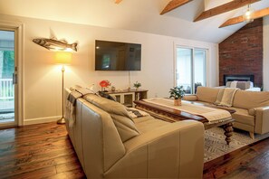 A living room with a sofa, a coffee table, a flat-screen TV, and a fireplace.