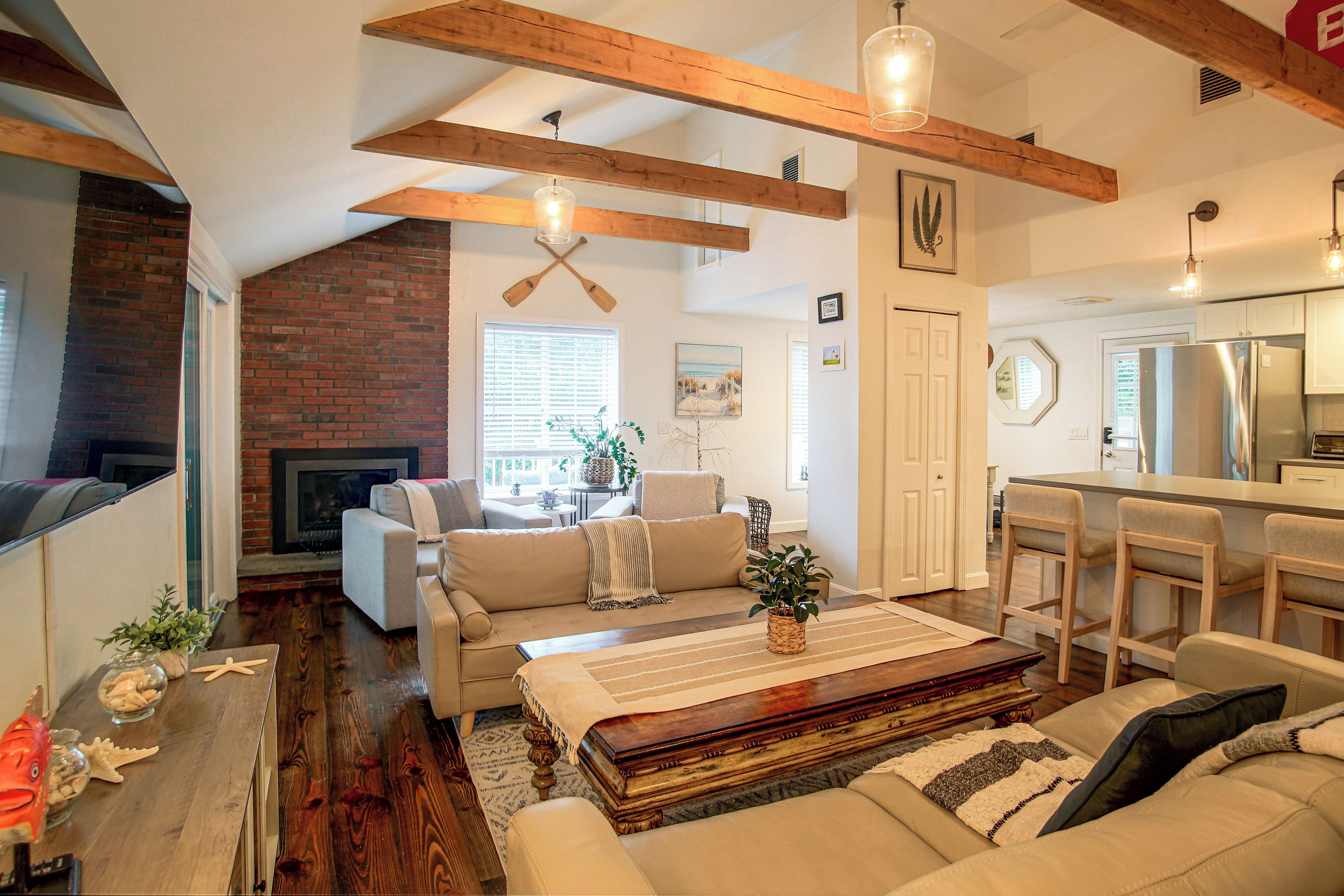 A spacious living room with a fireplace, a dining area with a bar, and a kitchen with modern appliances.