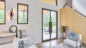 A modern kitchen with a marble countertop, a built-in sink, and a ceiling fan. - 65 Acres: Secluded 'avian Acres' Cabin w/ Pool! (Burkeville)