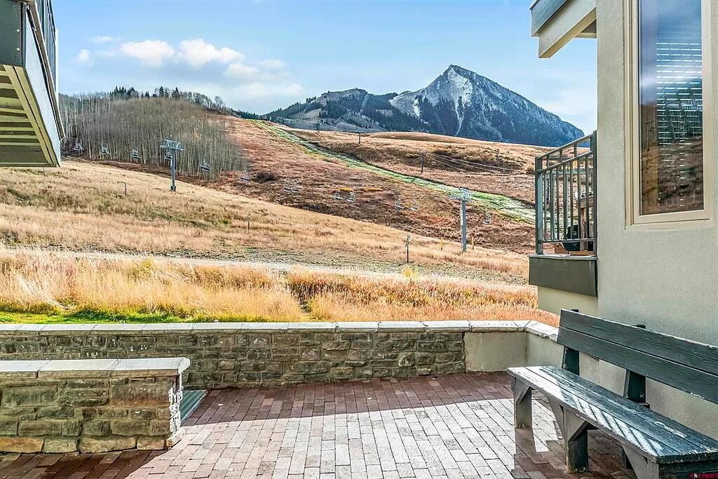 A stone bench and a paved area with a mountain view.
