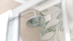 Un pommeau de douche avec un manche blanc et un couvercle transparent.