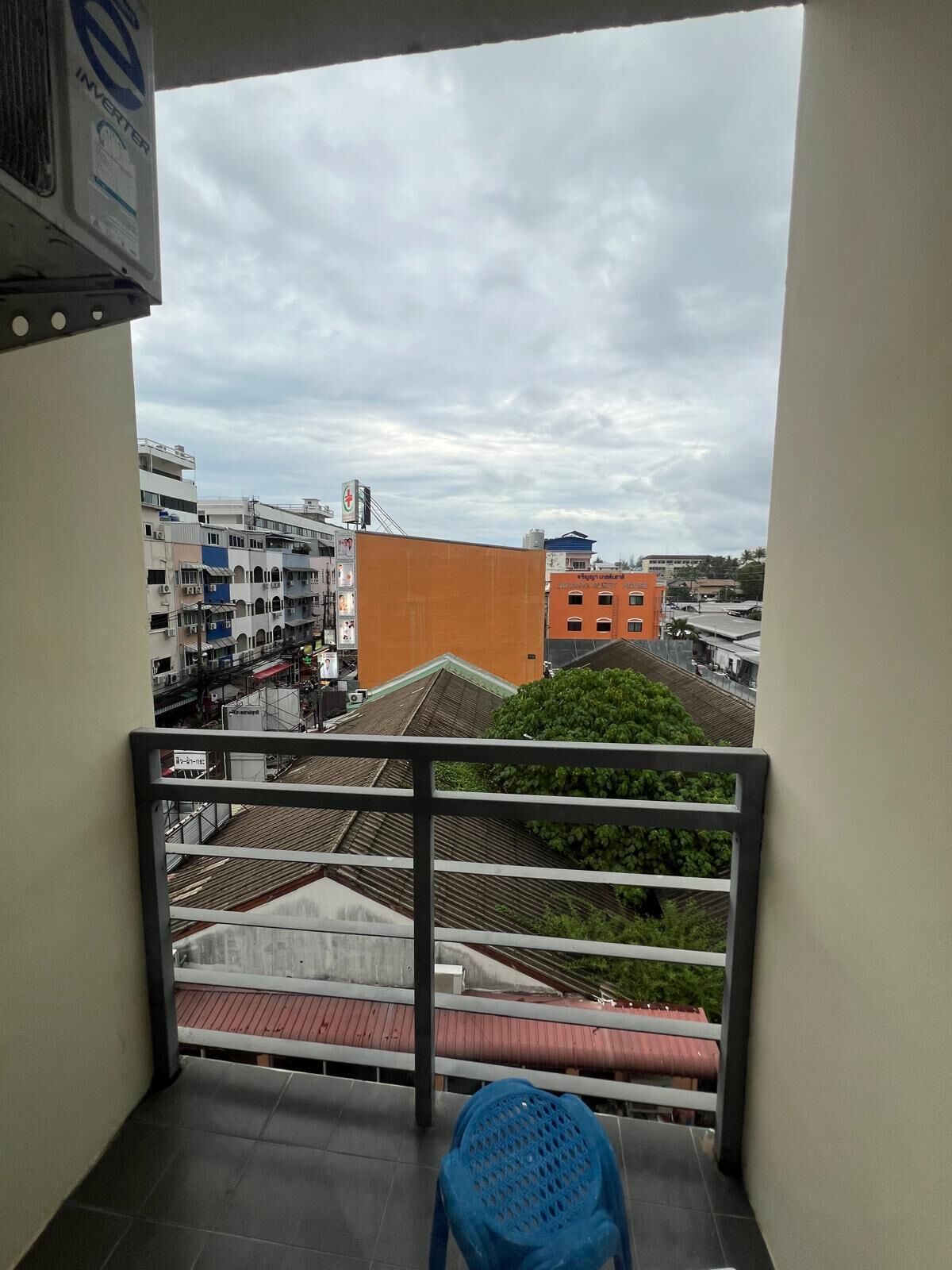 A balcony with a view of a cityscape, including buildings and a clear sky.
