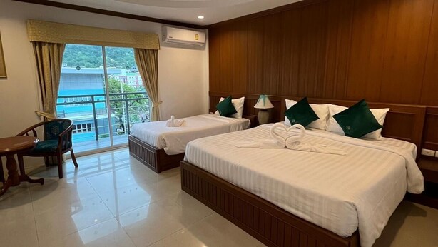 A hotel room with two beds, a desk, and a chair. - SK Residence And Restaurant Patong  (Patong)
