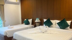 A hotel room with two beds, wooden headboards, white linens, and green pillows. - SK Residence And Restaurant Patong  (Patong)