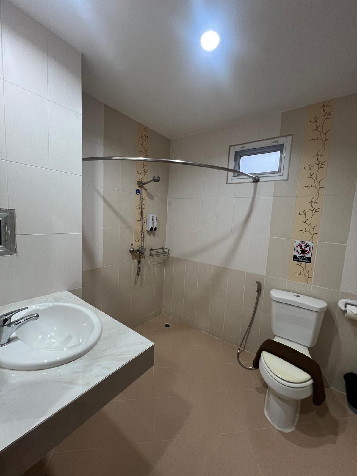 Un baño con lavamanos, inodoro y ducha blancos.